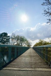 Footbridge over footpath against sky