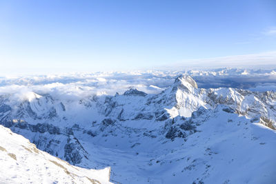Scenic view of snowcapped mountains against blue sky