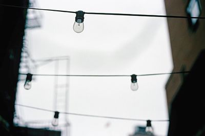 Low angle view of overhead cable car against sky