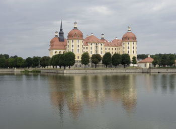 View of buildings and water against cloudy sky