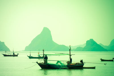 Sailboats in sea against clear sky