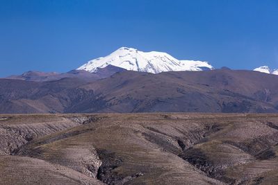 Scenic view of mountains against blue sky