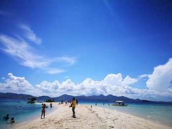 People at beach against sky