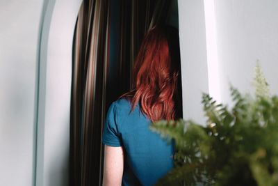 Midsection of woman standing by window