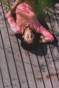 High angle view of woman lying on hardwood floor