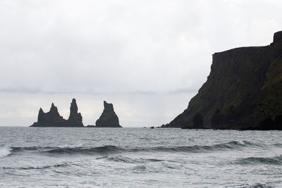 Rock formations by sea against sky