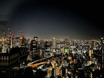 Illuminated cityscape against sky at night