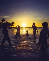 Silhouette people at beach during sunset