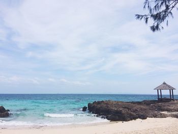 Scenic view of beach against cloudy sky