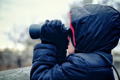 Young woman looking through binoculars