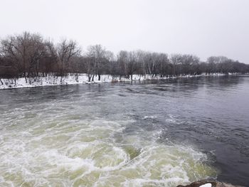 Scenic view of river against clear sky during winter