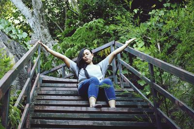 Full length portrait of young woman standing on staircase