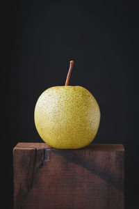 Close-up of fruit on table against black background