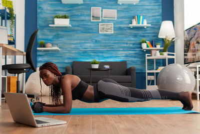 Side view of woman planking at home