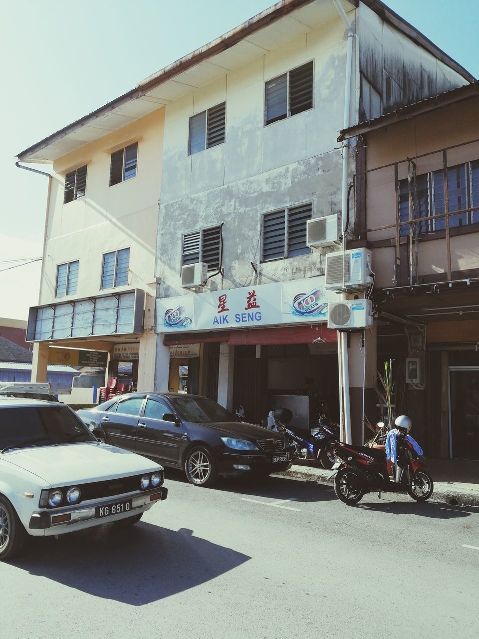 CARS PARKED ON STREET BY BUILDINGS IN CITY