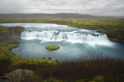 Scenic view of waterfall against sky