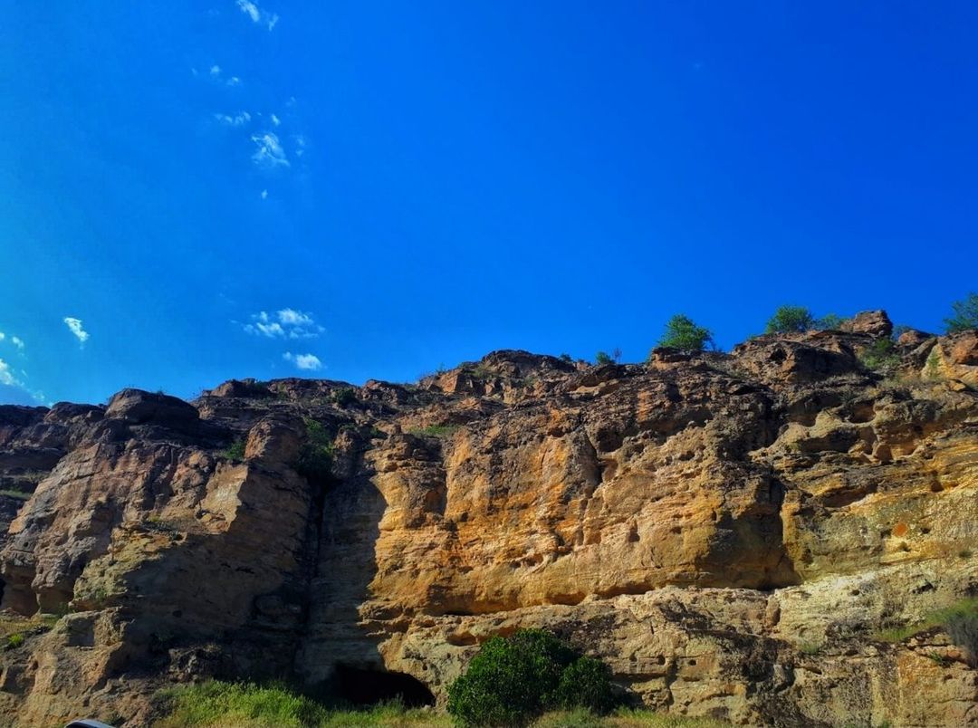 sky, rock, rock formation, blue, rock - object, nature, beauty in nature, solid, low angle view, tranquil scene, scenics - nature, tranquility, mountain, day, no people, environment, geology, non-urban scene, land, cliff, formation, outdoors, climate, arid climate, eroded