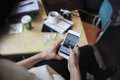 High angle view of blogger using smart phone in creative office