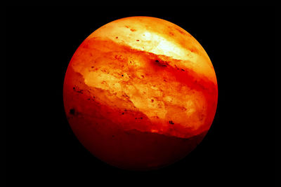 Close-up of orange slice over black background