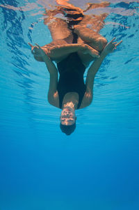 Female model meditating in pool
