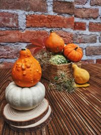 Close-up of orange pumpkins on table against wall