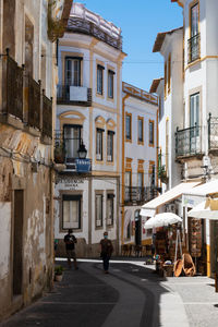 People walking on street amidst buildings in city