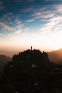 Silhouette rocks on rock formation against sky during sunset