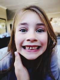 Close-up portrait of cute smiling girl at home