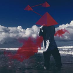 Digital composite image of man with red triangle shape mask at beach