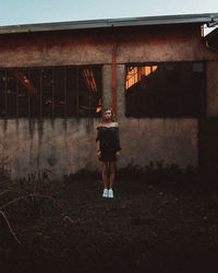 Portrait of woman standing against building