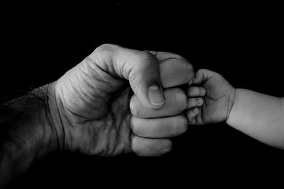 Close-up of hand holding glass over white background