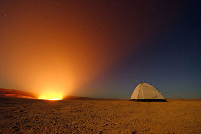 Tent on land against clear sky at night