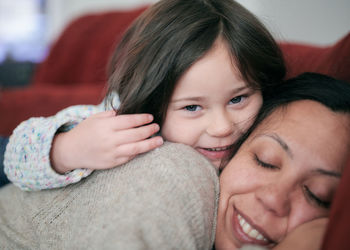 Young girl hugging mom with affection