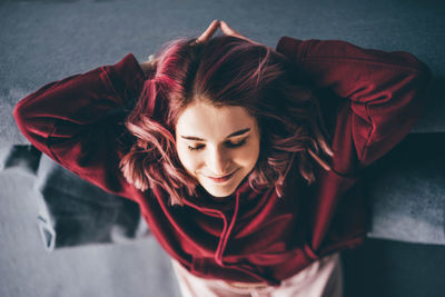 Portrait of young woman standing against wall