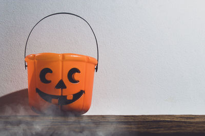 Close-up of pumpkin on table against wall