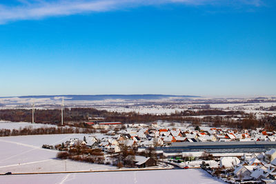 High angle view of snow covered landscape against blue sky