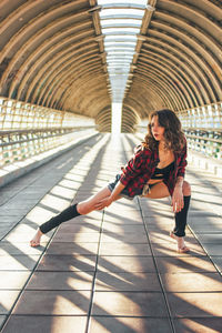 Full length of beautiful female dancer performing on pedestrian bridge