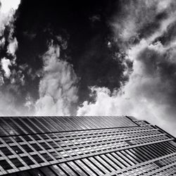 Low angle view of modern building against cloudy sky