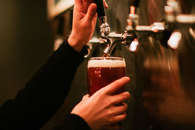 Female hands pouring beer