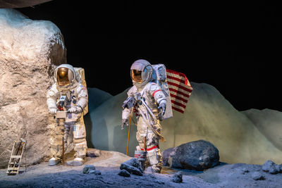 People standing on rock against sky at night