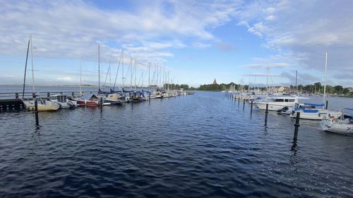 Sailboats moored in harbor