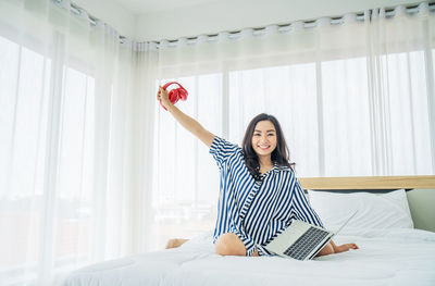 Full length of young woman using mobile phone
