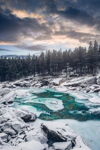 Scenic view of frozen landscape against sky during winter