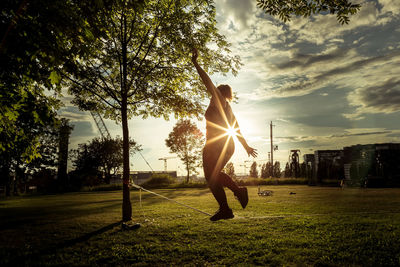 Man standing on field against sky during sunset