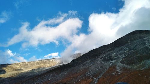 Low angle view of mountain against cloudy sky