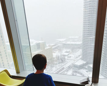 High angle view of boy looking through window