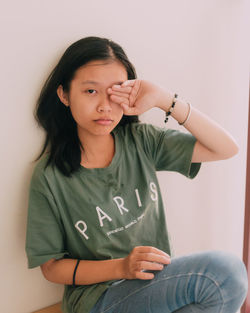 Portrait of boy sitting against wall