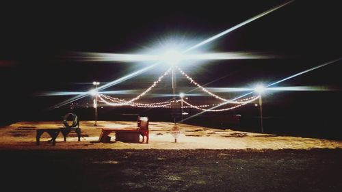 Rear view of people at beach against sky at night