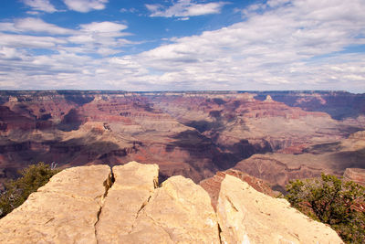 Rock formations on landscape against cloudy sky