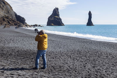 Rear view of a tourist photographing the cliff